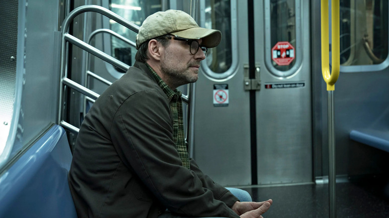 Mr. Robot (Christian Slater) sits in a subway car in Mr. Robot