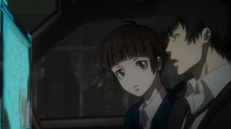 Akane Tsunemori and Shinya Kogami study a monitor in Psycho-Pass