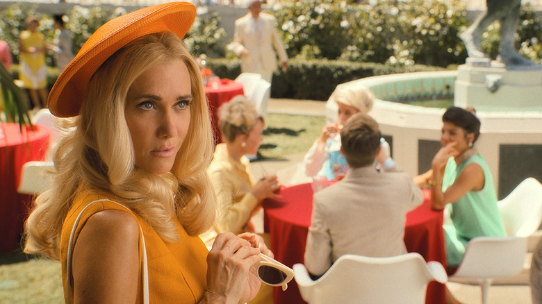 Kristen Wiig as Maxine in orange 1960s outfit in Palm Royale