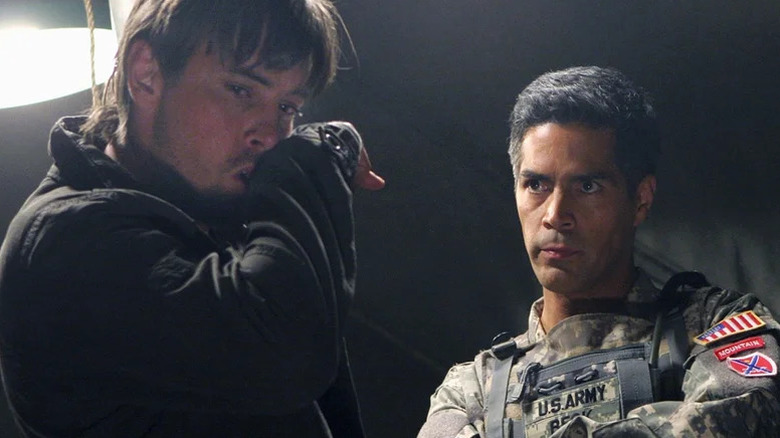 Jake Green wiping his face with his hand while Major Edwards looks at him