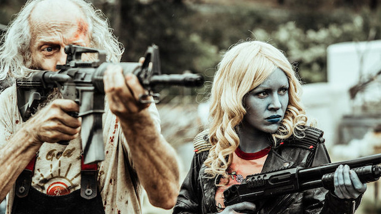 Doc and blue-faced Lucy, both holding automatic weapons