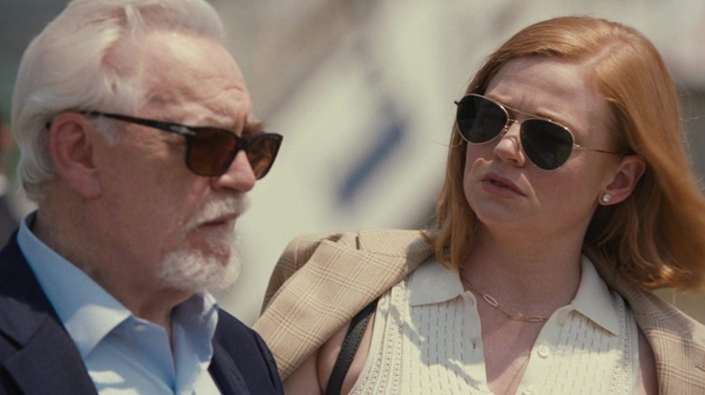 Logan and Shiv Roy standing next to each other with sunglasses on on Succession S3E1