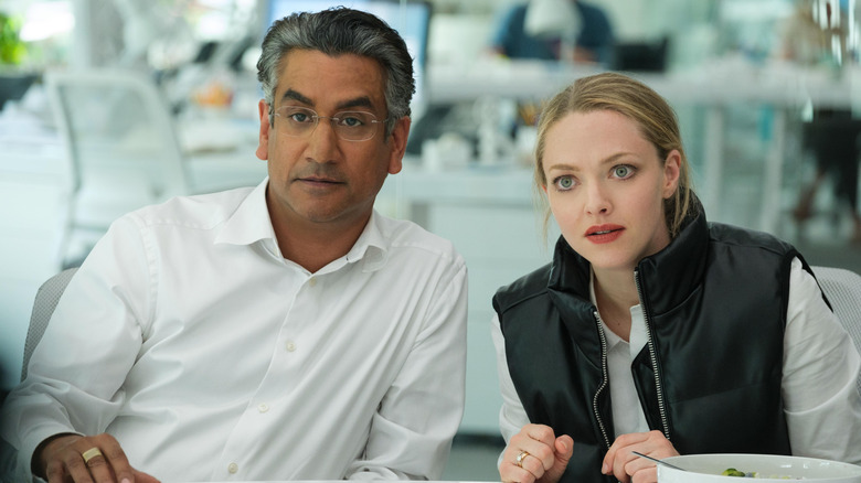 Naveen Andrews as Sunny Balwani and Amanda Seyfried as Elizabeth Holmes sitting together in The Dropout