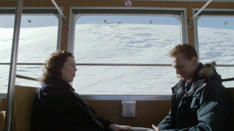 Angela Burr and Jonathan Pine sitting across from each other in a train on The Night Manager S1E2