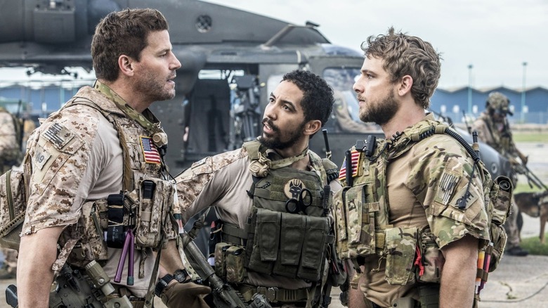Jason Hayes (David Boreanaz), Clay Spenser (Max Thieriot), and Ray Perry (Neil Brown Jr.) talking outside while armed in SEAL Team