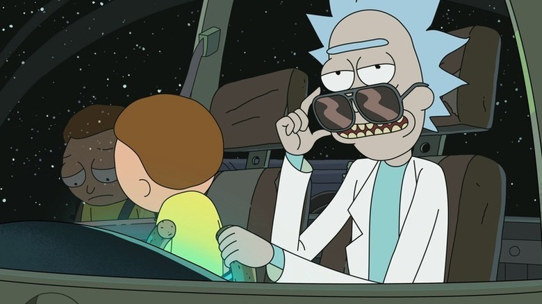 Rick Sanchez lowers his sunglasses while piloting a spaceship as Morty Smith in Rick and Morty