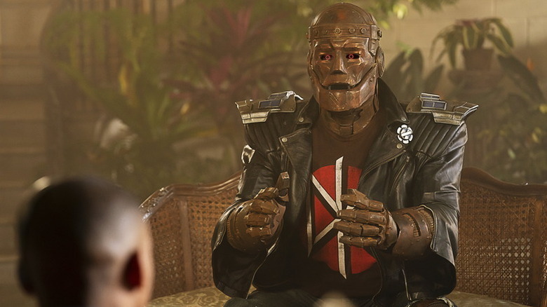 Robotman sits on a couch speaking to Cyborg