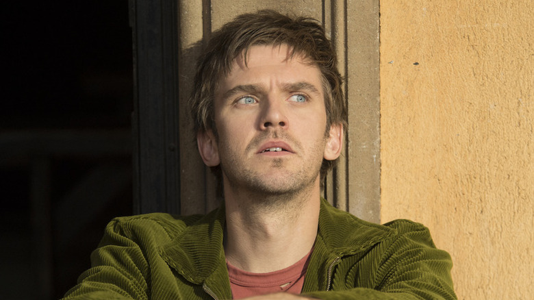 David Haller leans against a wall contemplatively