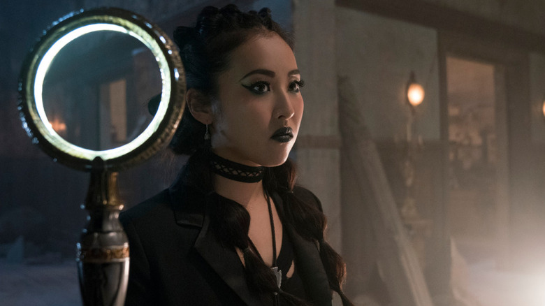 Nico Minoru stands next to a glowing staff