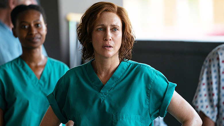 Dr. Anna Pou standing with hands on hips in turquoise scrubs