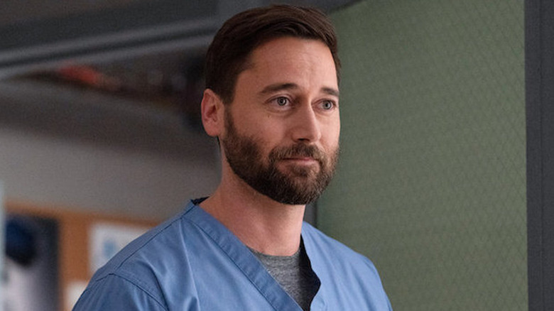 Dr. Max Goodwin wearing blue scrubs and smiling