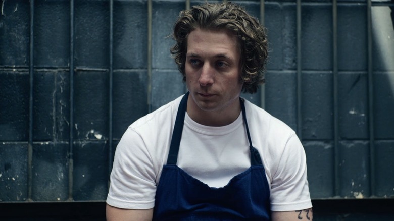 Carmy Berzatto in white shirt and apron, looking on