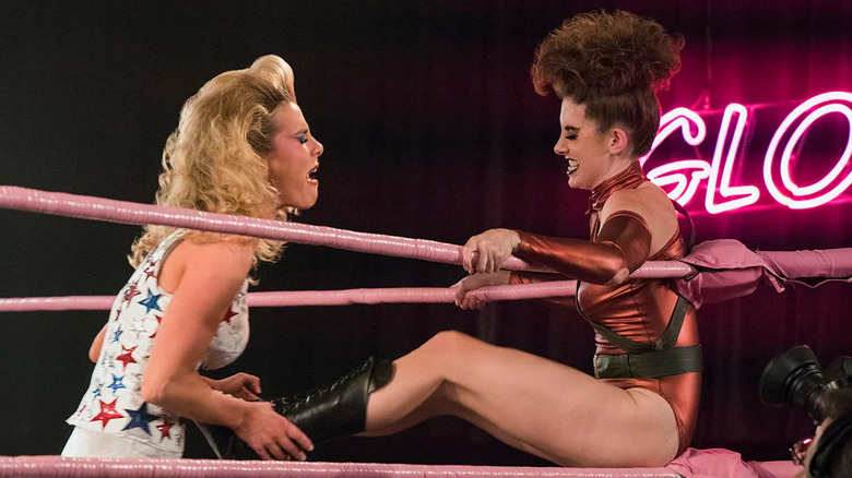 Betty Gilpin as Debbie being kicked by Alison Brie as Ruth in a wrestling ring in "GLOW."