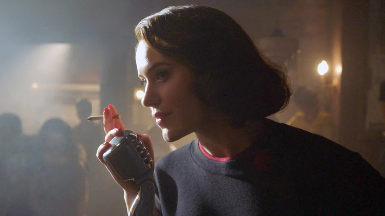 Rachel Brosnahan as Midge Maisel smoking a cigarette near a microphone in The Marvelous Mrs. Maisel