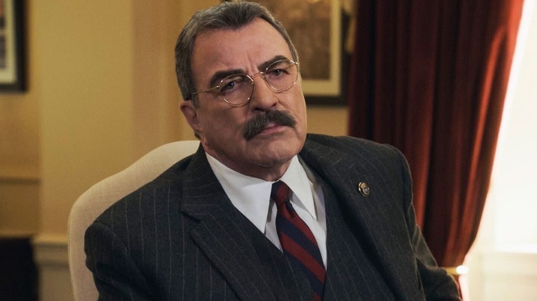 Frank Reagan (Tom Selleck) looks up while seated in an armchair in Blue Bloods