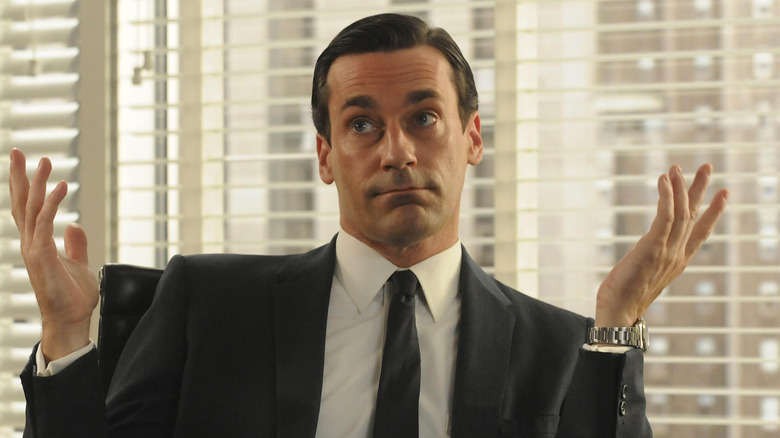 Jon Hamm as Don Draper, raising his hands in Mad Men.