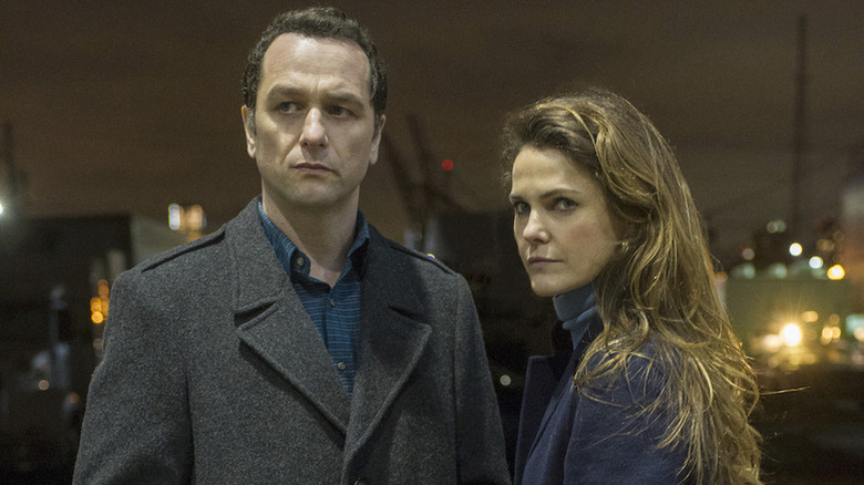 Matthew Rhys as Philip and Keri Russell as Elizabeth standing outside looking severe in The Americans