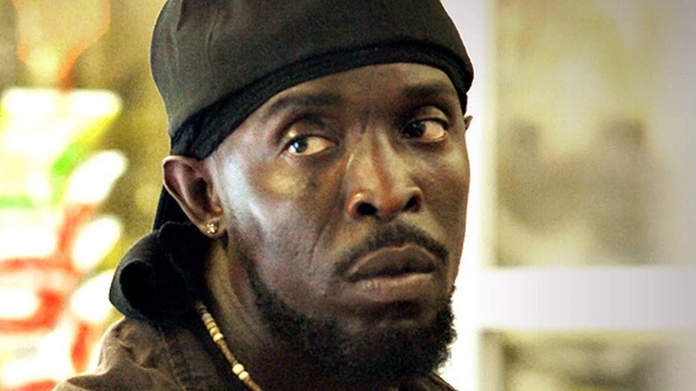 Michael K. Williams as Omar Little with scar on face wearing durag and black hat in The Wire