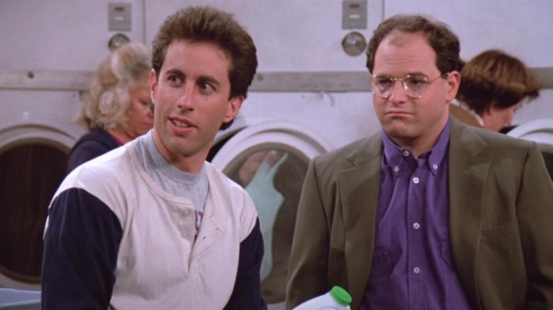 Jerry Seinfeld as Jerry and Jason Alexander as George standing in a laundromat in Seinfeld.
