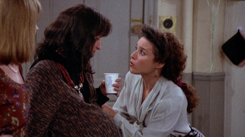 Julia Louis-Dreyfus as Elaine looking worried while talking to Christine Dunford as Leslie in Seinfeld.