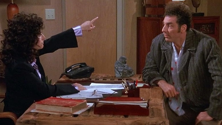 Julia Louis-Dreyfus as Elaine pointing up at Michael Richards as Kramer in Seinfeld.