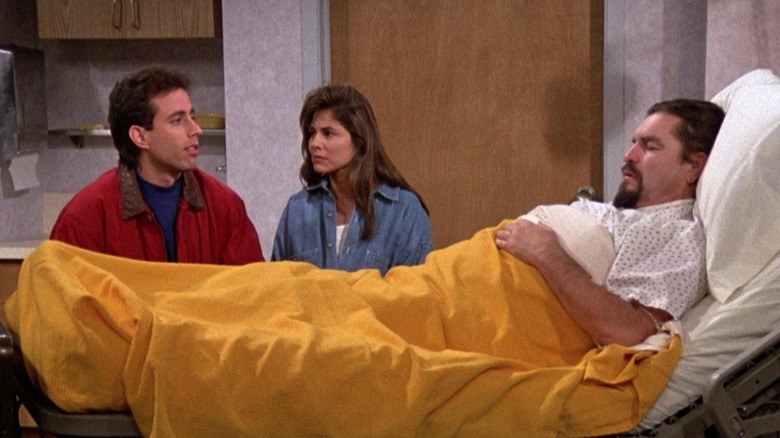 Jerry Seinfeld as himself sitting next to Gina Gallego as Gina near the hospital bed of C.E. Grimes as Martin in Seinfeld.