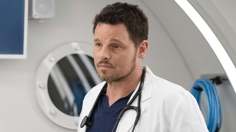 Alex Karev (Justin Chambers) stands solemnly in a hospital in Grey's Anatomy