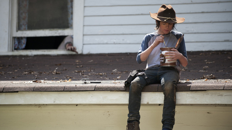 Carl Grimes (Chandler Riggs) eats a bowl of pudding on a roof in The Walking Dead