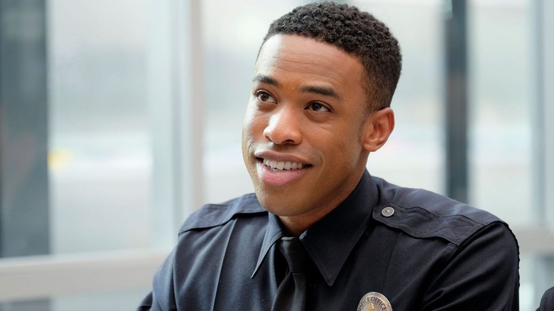 Jackson West (Titus Makin Jr.) smiles while wearing his police uniform in The Rookie