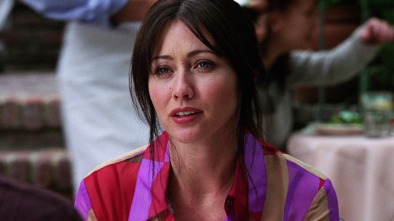 Prue Halliwell (Shannen Doherty) sits in a restaurant in Charmed (1998)