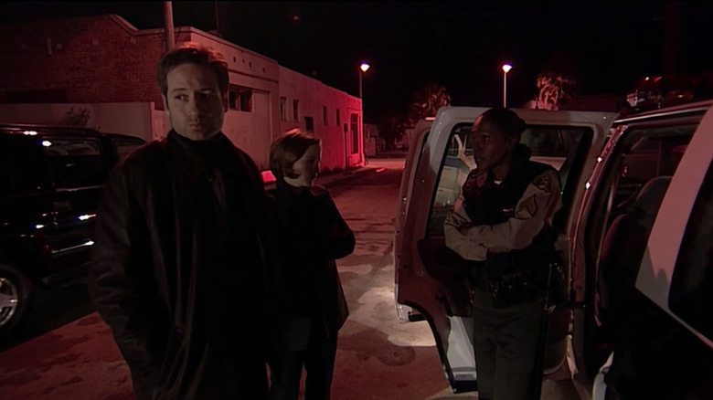 Mulder and Scully confer with a police officer in "The X-Files"