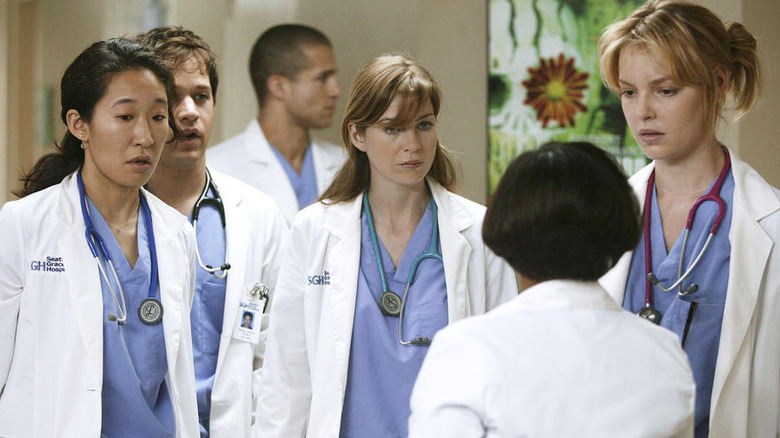 Cristina (Sandra Oh), George (T.R. Knight), Meredith (Ellen Pompeo), and Izzie (Katherine Heigl) looking at Miranda (Chandra Wilson) on Grey's Anatomy