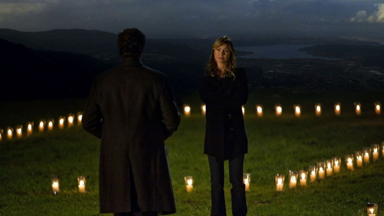 Meredith (Ellen Pompeo) standing in the house of candles talking to Derek (Patrick Dempsey) on Grey's Anatomy