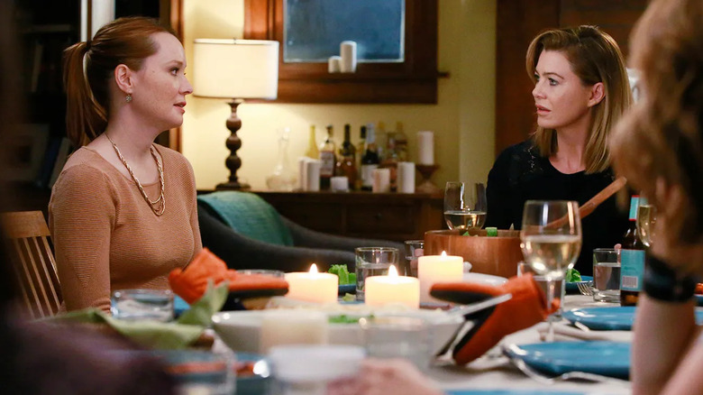 Penny (Samantha Sloyan) and Meredith (Ellen Pompeo) looking at each other at the dinner table on Grey's Anatomy