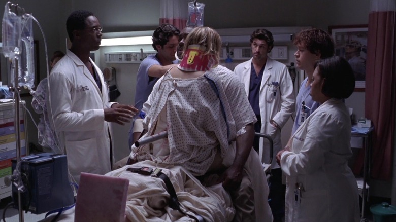 Burke (Isaiah Washington), Derek (Patrick Dempsey), George (T.R. Knight), and Miranda (Chandra Wilson) looking at the patients on a pole on Grey's Anatomy