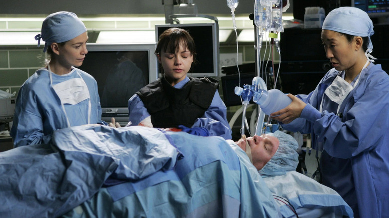 Meredith (Ellen Pompeo), Hannah (Christina Ricci), and Cristina (Sandra Oh) taking care of a patient in the OR on Grey's Anatomy