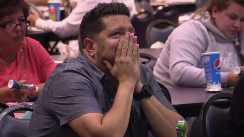 Sal worriedly covering his mouth and nose while sitting at a bingo table on Impractical Jokers S3E29