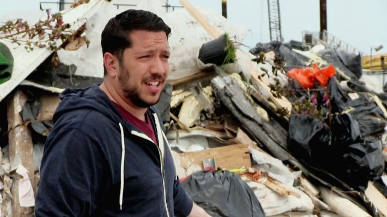 Sal standing next to a pile of garbage on Impractical Jokers S2E16