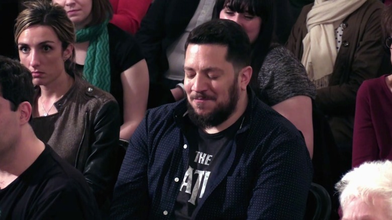 Sal trying to hold back laughter while sitting in an audience on Impractical Jokers S5E11