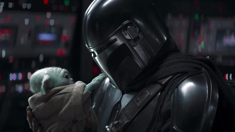 Grogu reaching out to touch Din Djarin's mask in The Mandalorian