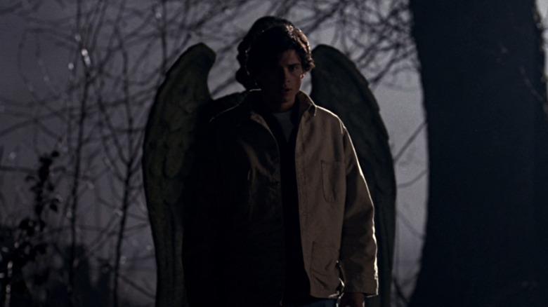 Clark Kent standing in a graveyard