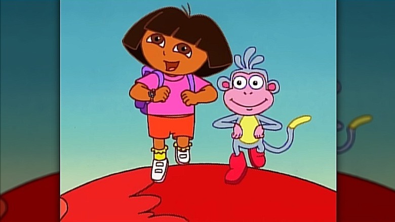 Dora and Boots standing on top of a large red chicken in "Dora the Explorer" (2000)