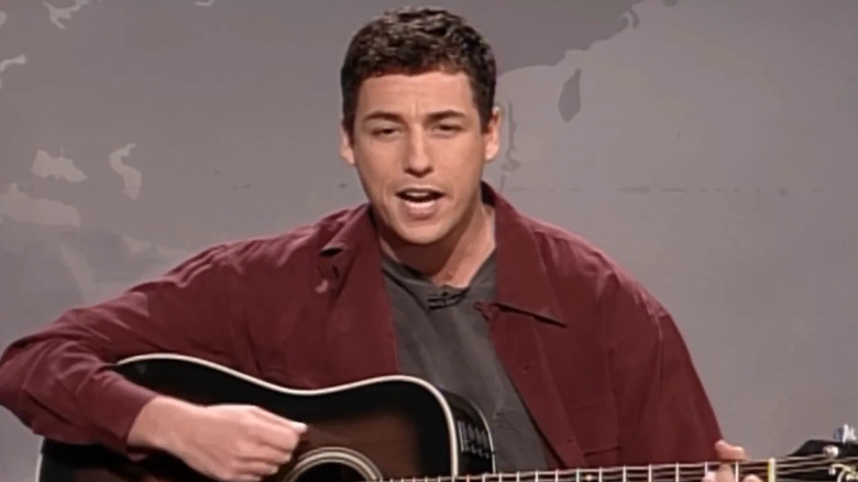 Adam Sandler playing guitar during Weekend Update on SNL