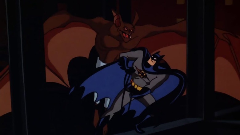 Batman in a gray superhero costume with ablack/blue cape and cowl fighting a large brown bat creature.
