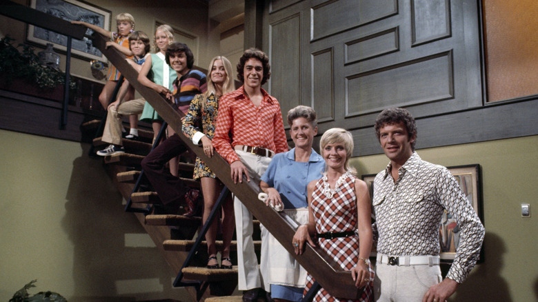 The main cast of The Brady Bunch posing on the family staircase in Season 4