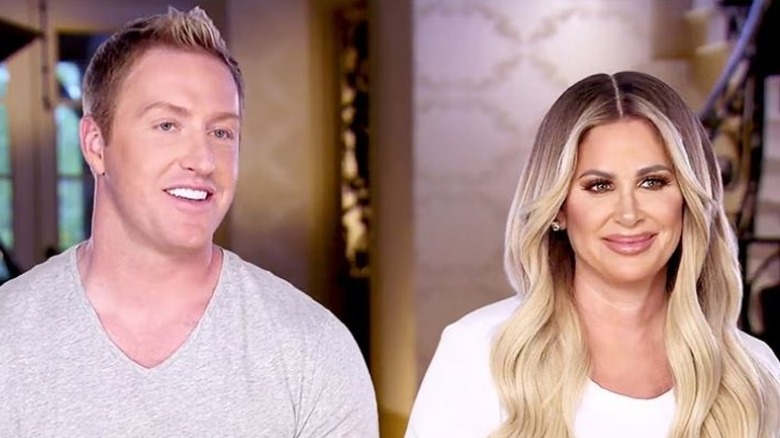 Kroy Biermann and Kim Zolciak smiling in a confessional on Don't Be Tardy