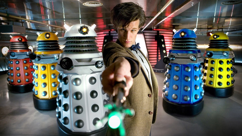 Matt Smith as the Eleventh Doctor, standing in front of the technicolor Paradigm Daleks, on Doctor Who.