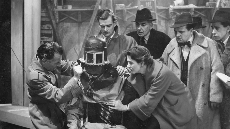 An astronaut's helmet is removed upon his return to Earth on the early sci-fi series, The Quatermass Experiment.