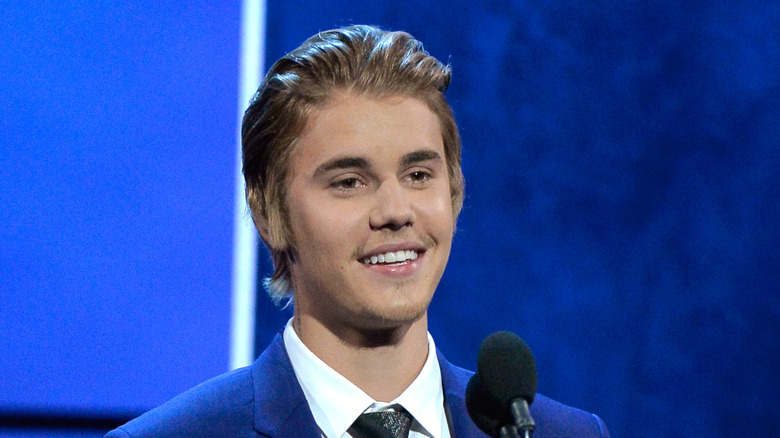 Justin Bieber in blue suit speaking at his roast
