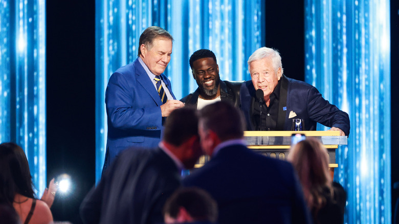 BIll Belichik, Kevin Hart, and Robert Kraft on stage at roast of Tom Brady